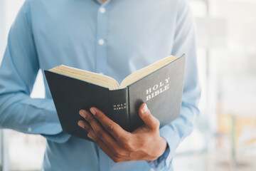 Man holding and reading the holy Christian Bible.