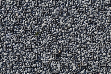 A symmetrical design constructed of metal rings and pebbles.