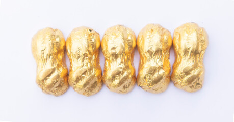 .Chocolate wrapped in gold paper, close-up of a few ounces of chocolate. On a white background