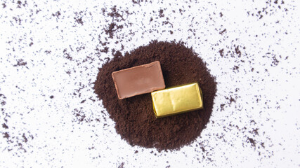 Close-up of a few ounces of chocolate on cocoa powder. On a white background