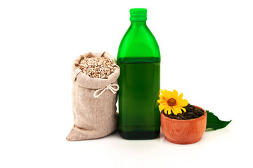 Sunflower oil in glass bottle, sunflower seeds in sack and rustic wooden bowl with flower and leaves on white background - 376961083
