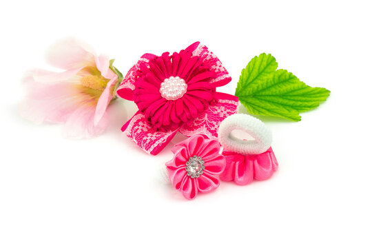 Barrette with ribbon and elastic, flowers and green leaf isolated on white background.