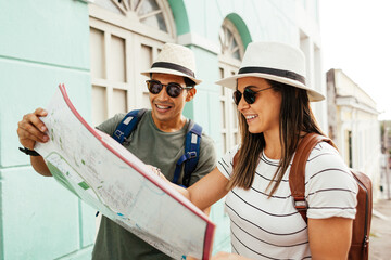 Happy tourist couple using the map. Travel and love concept in Latin America