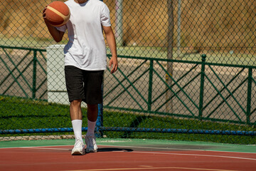 Obraz premium Young man on basketball court dribbling with ball