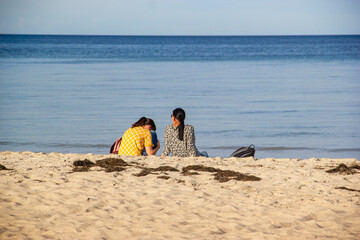 two girlfriends sitting on the beach