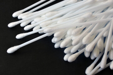 Cotton ear buds on a dark background.