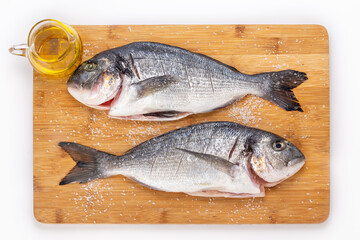 two fresh sea bream fish on a bamboo board
