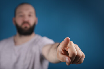 blue background young man finger pointing touch