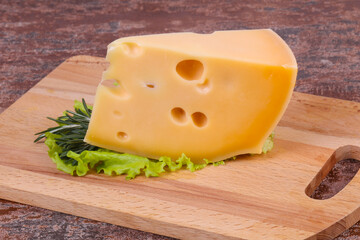 Maasdam cheese  in the board served salad leaves