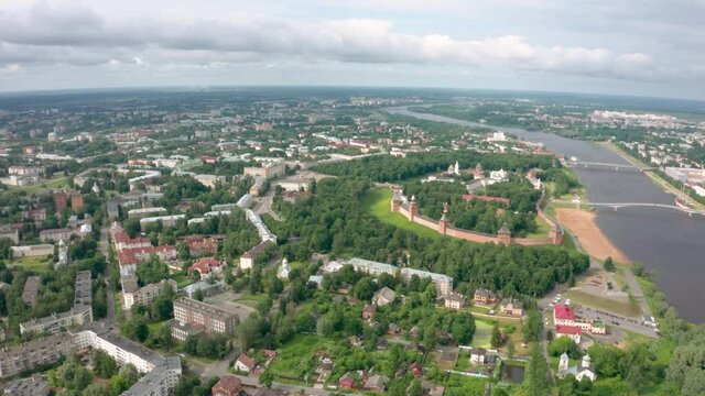 Panoramic aerial view of the Volkhov River and the old town of Veliky Novgorod, the red brick Kremlin in the rays of the setting sun and natural attractions of Russia.