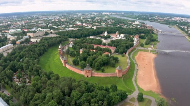 Panoramic aerial view of the Volkhov River and the old town of Veliky Novgorod, the red brick Kremlin in the rays of the setting sun and natural attractions of Russia.
