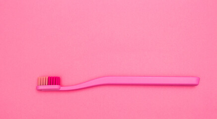 Pink toothbrush isolated on pink background. Pink toothbrush close up top view