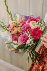Young florist woman holding freshly made blossoming flower bouquet