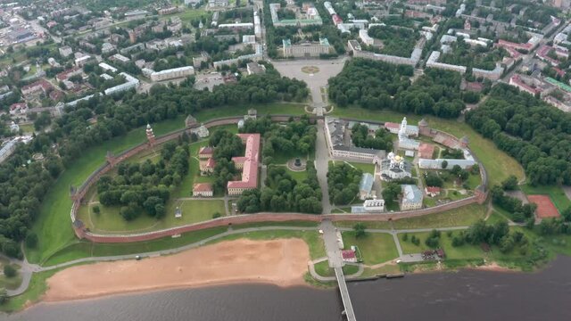 Panoramic aerial view of the Volkhov River and the old town of Veliky Novgorod, the red brick Kremlin in the rays of the setting sun and natural attractions of Russia.