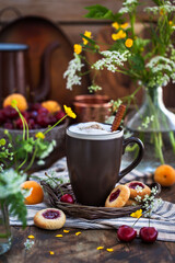 Cup of hot cappuccino coffee on summer rustic wooden background