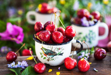 Fresh ripe cherries in a mug on summer background