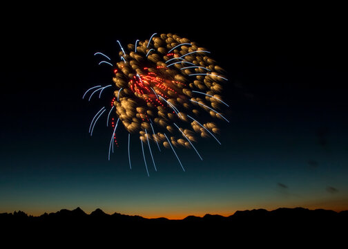 Vibrant fireworks at mountain range sunset  with sihouette of mountain range at sunset