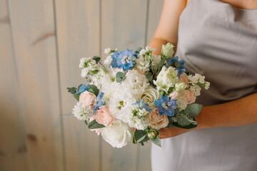 Very nice young woman holding big and beautiful colourful flower wedding bouquet