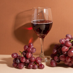 Wine time. Wine with grapes. Light background. Wineglass on the table. Idea for evening. Wine is...