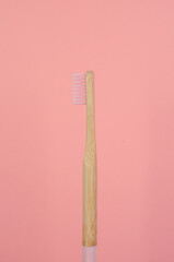 cepillo de dientes de bambú color rosa con fondo liso color rosa
