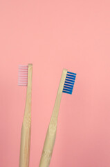 cepillos de dientes rosa azul de bambú con fondo liso color rosa