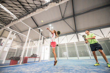 paddle tennis indoors training, woman hits ball