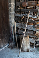 scythe, broom and shovel on the wooden background 