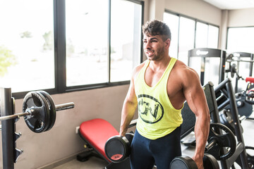 Fototapeta na wymiar Strong man lifting weights in gym