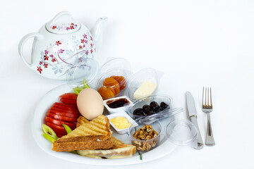 Traditional Turkish Breakfast Plate with boiled egg and tea on white surface.Top view