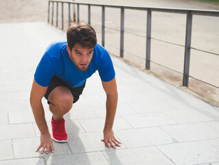 Bearded man dressed in sportswear is ready to run.