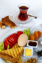 Traditional Turkish Breakfast Plate with boiled egg and tea on white surface.Top view