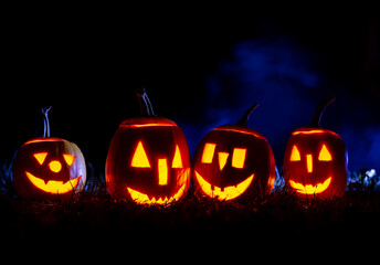 Halloween pumpkins over blue background with smoke with copy space.	