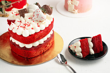  pastel redvelvet relleno de  vainilla  fresas con chocolate y una rebanada partida en un plato con...