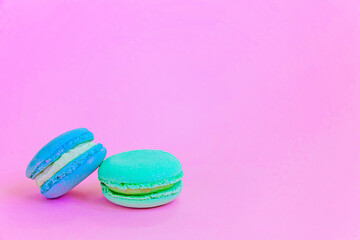 Sweet almond colorful unicorn blue green macaron or macaroon dessert cake isolated on trendy pink pastel background. French sweet cookie. Minimal food bakery concept Copy space