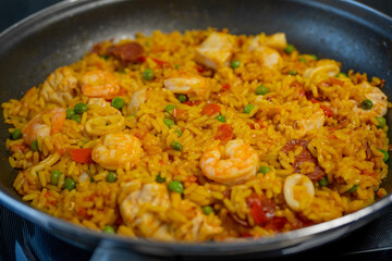 Sea Food Home made Paella Valenciana. Typical Spanish seafood paella in traditional pan. Macro close-up. Selective focus