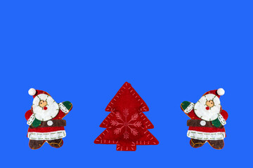 Christmas composition with toy Santa Claus and Christmas tree on a colored background