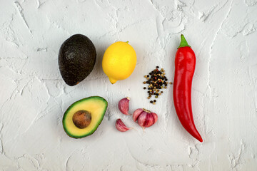 Ingredients for mexican sauce guacamole. Avocado, red hot peppers, garlic, lemon. Top view.