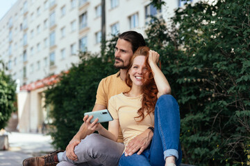 Young couple relaxing on a bench in town