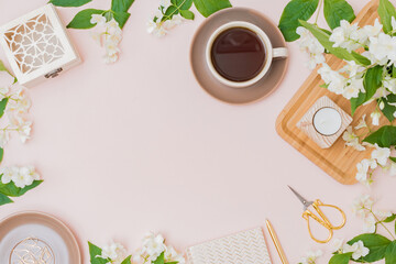 Flat lay composition with a cup of coffee and jasmine flowers on a color background