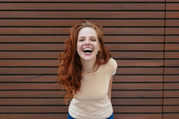 Laughing young woman leaning forwards to camera