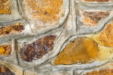 Abstract background made of rustic stone blocks layered in radom configuration and jointed by the cement 