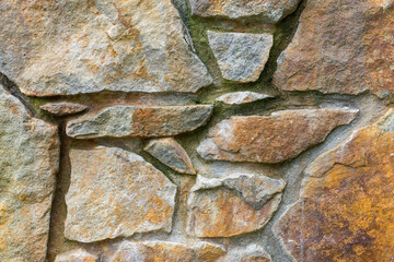 Rusty different size stone wall for background. Stone blocks as wall cladding
