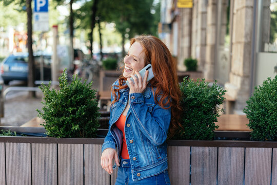 Happy young woman chatting on a mobile