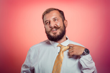Man loosing tie on red background. businessman in suit loosening up his tie - isolated on red