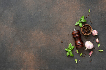Salt, peppercorns, fresh basil on a concrete background. View from above.