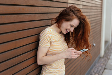Young woman engrossed in reading a phone message