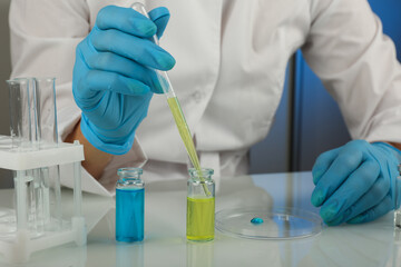 laboratory assistant's hands hold laboratory glassware during the research