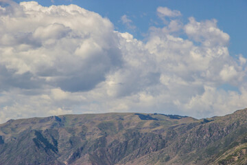 Landscape with hills, clouds and the blue sky. August scenery in Kazakhstani steppe.