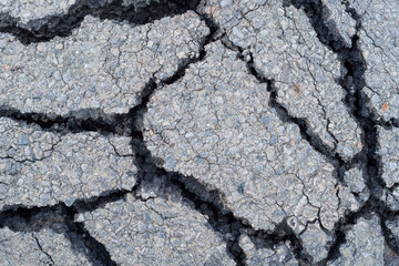 Cracked asphalt (bitumen) texture close up. Road surface material for background
