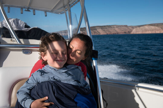A mom and her son cuddling on a sailing boat at Esp√≠ritu Santo Island.